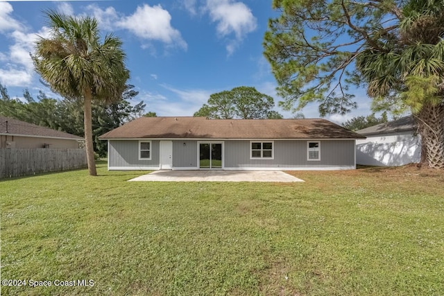 back of property with a lawn and a patio