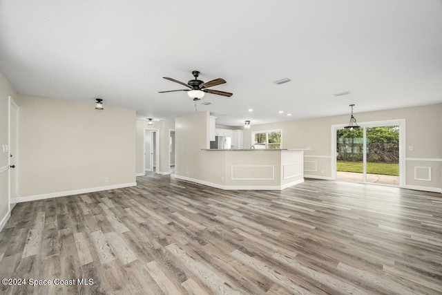 unfurnished living room featuring ceiling fan and light hardwood / wood-style flooring