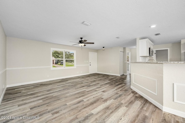 unfurnished living room featuring light hardwood / wood-style floors and ceiling fan