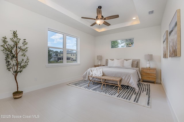 bedroom featuring a raised ceiling and ceiling fan