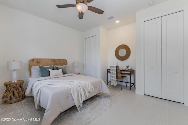 bedroom with multiple closets and ceiling fan