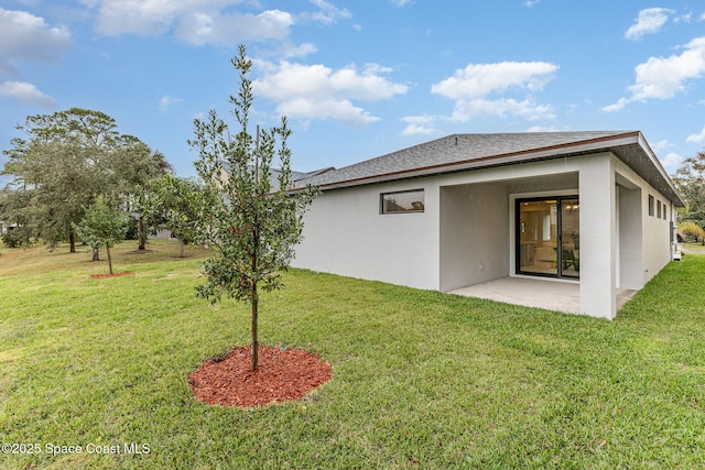 rear view of house featuring a yard and a patio