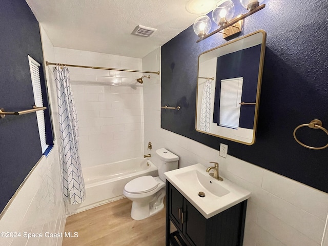 full bathroom with toilet, wood-type flooring, shower / tub combo with curtain, and tile walls