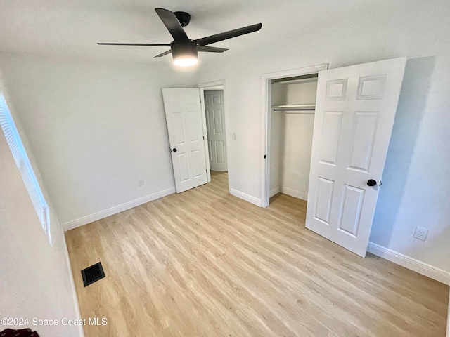 unfurnished bedroom featuring a closet, light hardwood / wood-style floors, and ceiling fan