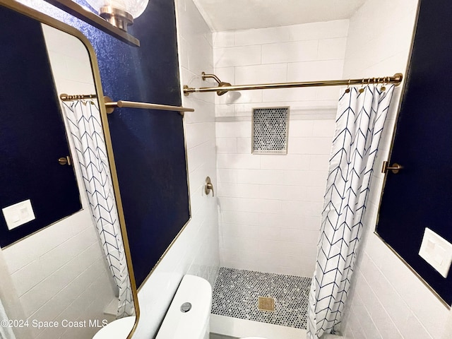 bathroom featuring toilet, tile walls, and walk in shower