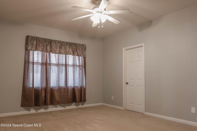 unfurnished room featuring light carpet, a textured ceiling, and ceiling fan