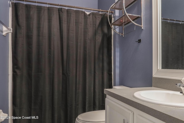 bathroom featuring a shower with shower curtain, vanity, and toilet