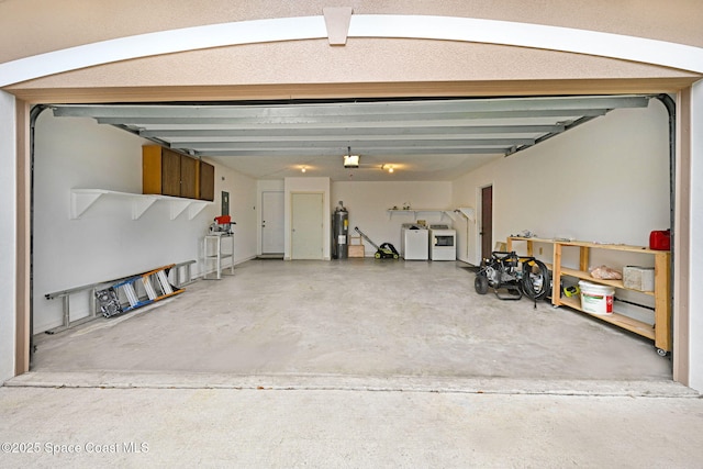 garage featuring separate washer and dryer and electric water heater