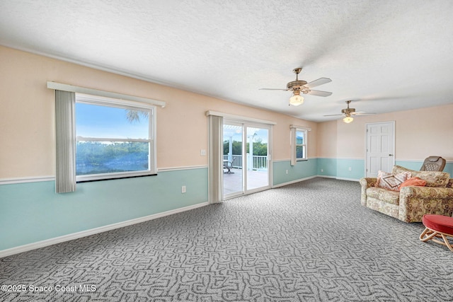 unfurnished living room featuring ceiling fan, carpet floors, and a textured ceiling