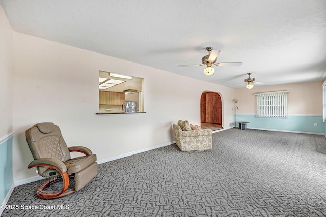 living area featuring carpet floors and ceiling fan