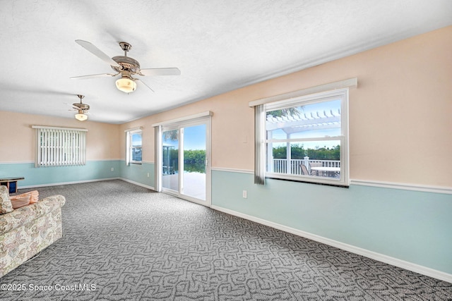 empty room with ceiling fan, a textured ceiling, and carpet floors