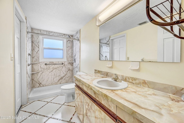 bathroom featuring toilet, a textured ceiling, a tile shower, and vanity