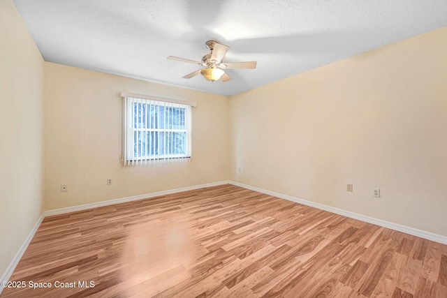 empty room with ceiling fan and light hardwood / wood-style flooring