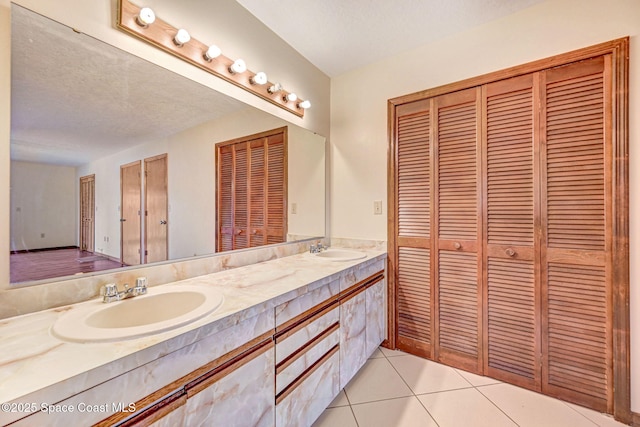 bathroom with a textured ceiling, tile patterned floors, and vanity