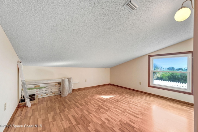 bonus room featuring lofted ceiling and light hardwood / wood-style flooring