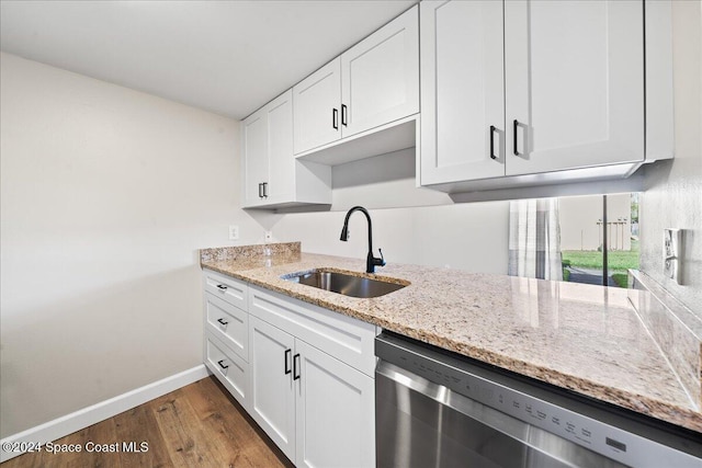 kitchen featuring dark hardwood / wood-style floors, white cabinetry, stainless steel dishwasher, and sink