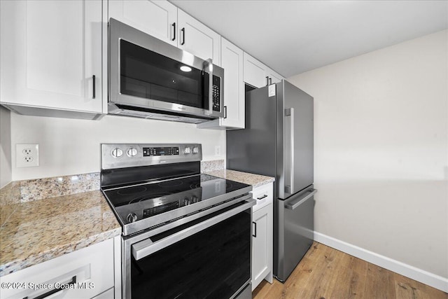 kitchen featuring white cabinets, stainless steel appliances, and light hardwood / wood-style floors