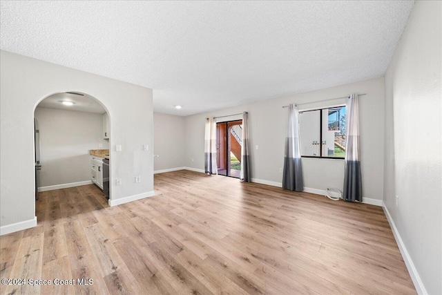 unfurnished room featuring a textured ceiling and light wood-type flooring