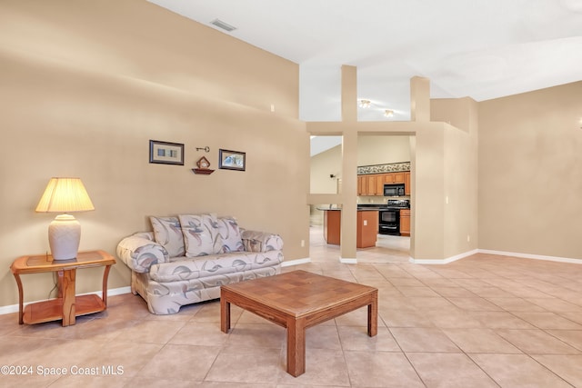 living room featuring light tile patterned floors and high vaulted ceiling