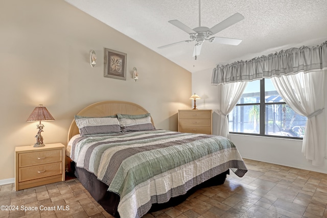 bedroom with a textured ceiling, ceiling fan, and vaulted ceiling