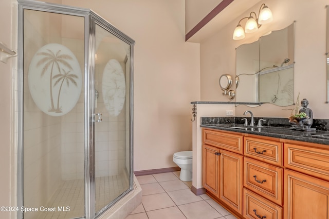 bathroom with tile patterned floors, a shower with door, vanity, and toilet