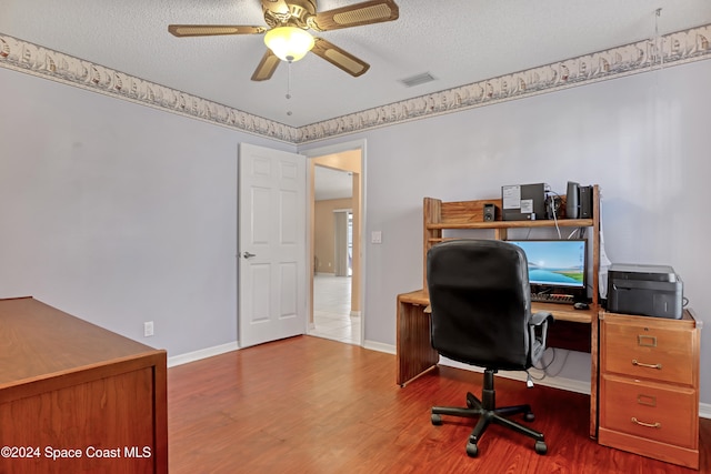 home office with ceiling fan, wood-type flooring, and a textured ceiling