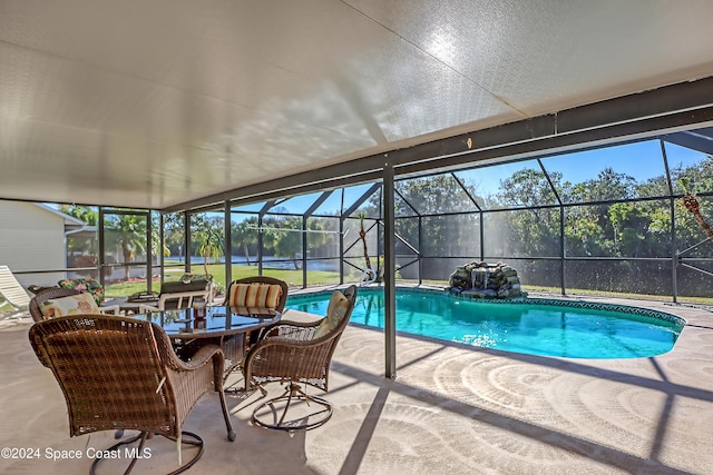 view of swimming pool featuring a lanai and a patio area