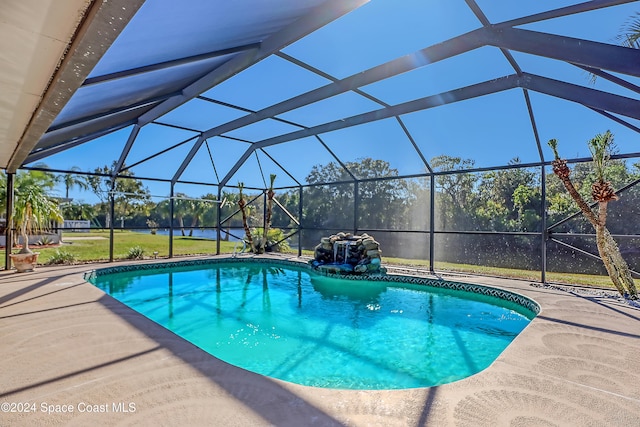 view of swimming pool featuring a patio area and a lanai