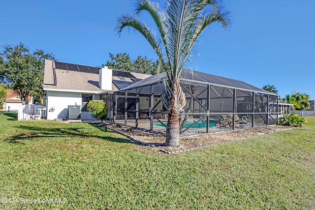 exterior space featuring central AC unit, glass enclosure, and a lawn