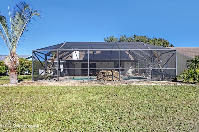 back of house featuring a lawn and glass enclosure