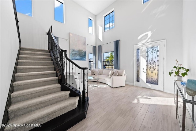 entryway featuring a high ceiling and light hardwood / wood-style flooring