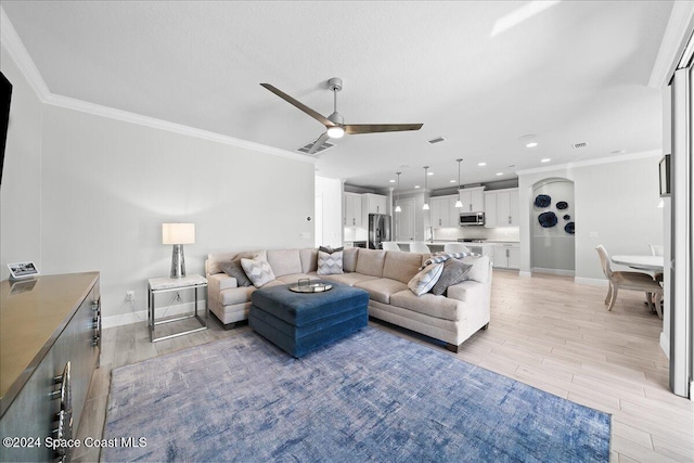 living room with ceiling fan, light hardwood / wood-style floors, and crown molding