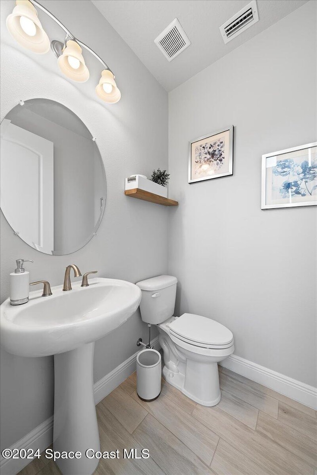 bathroom with hardwood / wood-style flooring, sink, and toilet