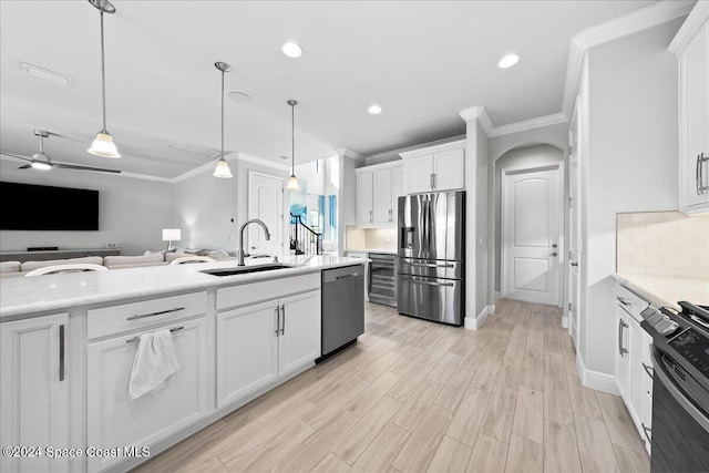 kitchen featuring white cabinets, sink, ceiling fan, appliances with stainless steel finishes, and decorative light fixtures