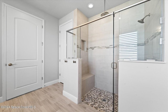 bathroom featuring hardwood / wood-style flooring and walk in shower