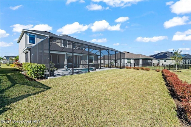 back of house featuring a lawn, a lanai, and a pool