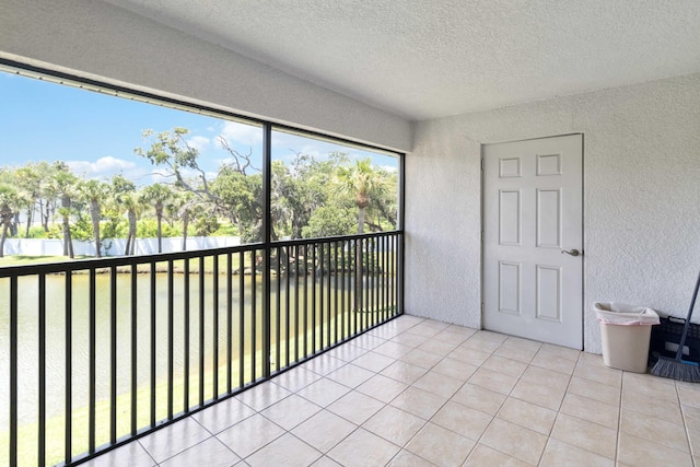 unfurnished sunroom featuring a water view