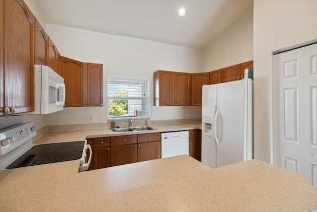 kitchen with kitchen peninsula, white appliances, vaulted ceiling, and sink