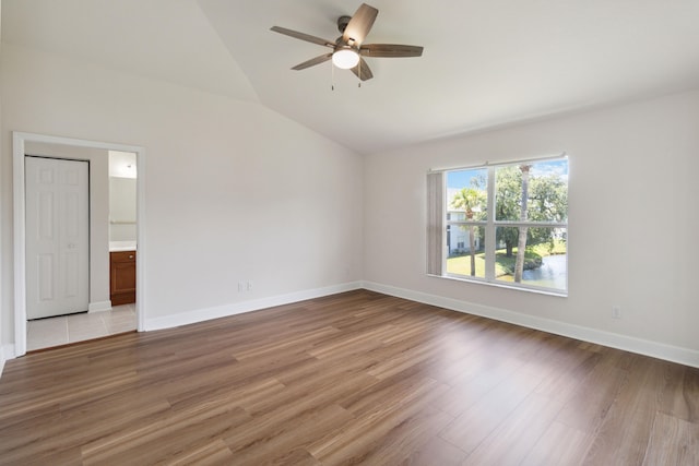 empty room featuring ceiling fan, lofted ceiling, and light wood-type flooring