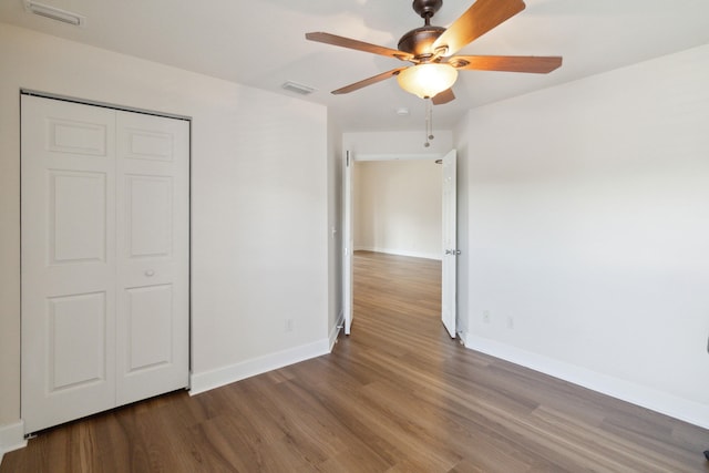 unfurnished bedroom featuring a closet, hardwood / wood-style flooring, and ceiling fan