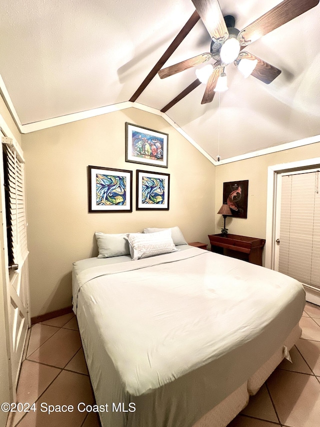 bedroom featuring ceiling fan, light tile patterned flooring, and vaulted ceiling