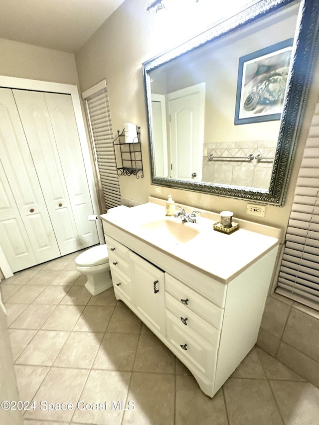 bathroom with tile patterned flooring, vanity, and toilet