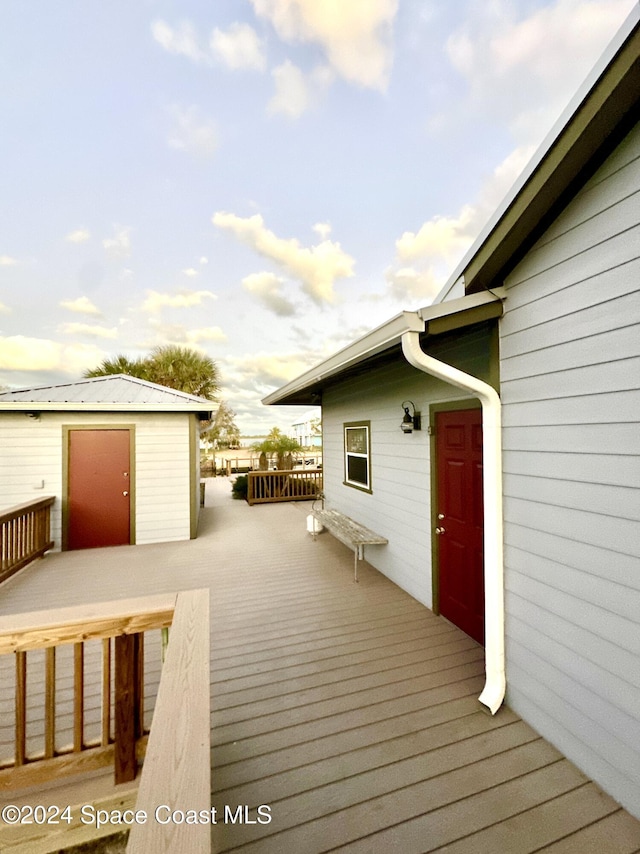 deck at dusk featuring an outbuilding