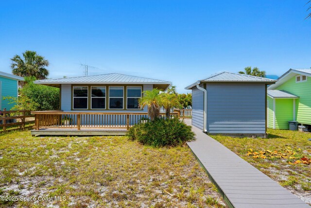 36 Vip Is Unit A, Grant, FL 32949 - rear view of house featuring metal roof, a wooden deck, and a lawn