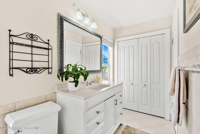 36 Vip Is Unit A, Grant, FL 32949 - bathroom featuring toilet, vanity, tile patterned flooring, tile walls, and a closet