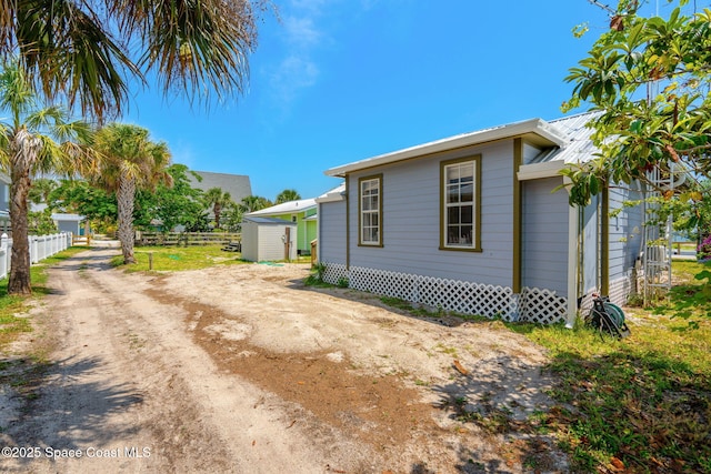 36 Vip Is Unit A, Grant, FL 32949 - view of home's exterior with fence, an outdoor structure, metal roof, and a storage shed