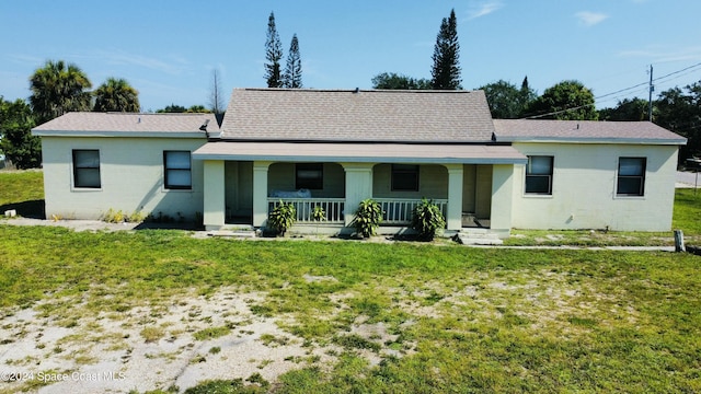 back of property featuring a yard and covered porch