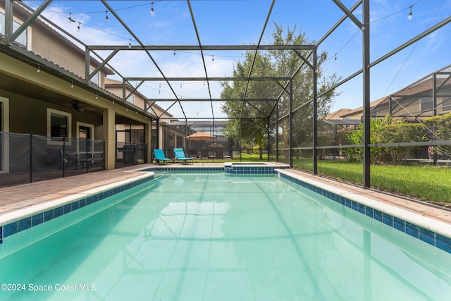 view of swimming pool featuring glass enclosure, ceiling fan, and a patio