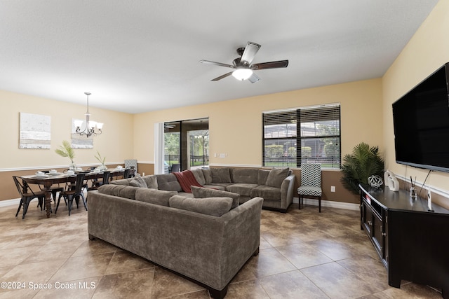 living room featuring tile patterned floors and ceiling fan with notable chandelier