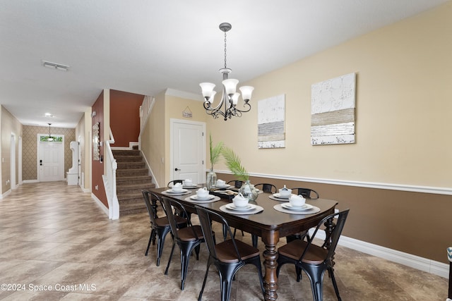 dining space featuring tile patterned floors and an inviting chandelier